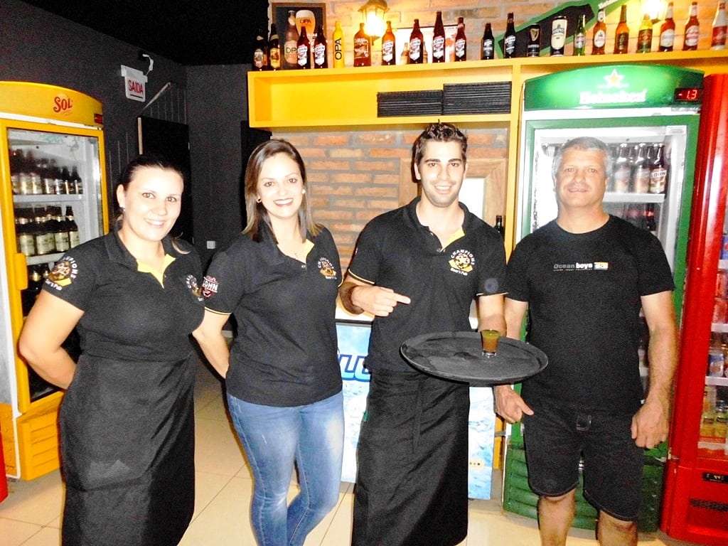 Marcelo Branco: Neste domingo haverá a abertura do natal luz e programação natalina na Praça Humberto Bortoluzzi 4 A Champions Beer’s Pub, de Forquilhinha, fica na Avenida Eurico Back.  A casa  é uma das melhores opções etílico-gastronômica da cidade e abre de quarta-feira a domingo. O proprietário é o bacana João Batista, o “Janga”, conhecido deste meio. Sua equipe de quarta-feira formada pelo barman Estevan e as garçonetes Joana e Aline. O local é amplo, charmoso e aconchegante. A Champions serve tábuas, porções,  saborosos petiscos, batata recheada, chuleta na tábua, e demais pratos à  la carte. Na quarta-feira tem rodízio de pizzas e chope em dobro. Para beber tem drinques especiais, chope Lonh Beer e muito mais opções de bebidas. Aos sábados tem música ao vivo. Para chegar na Champions no sentido Nova Veneza/Forquilhinha você deve contornar a rótula próxima à JBS e seguir à esquerda, fica próximo ao lado direito da avenida. Fone: (48) 3463-4094. Confira.